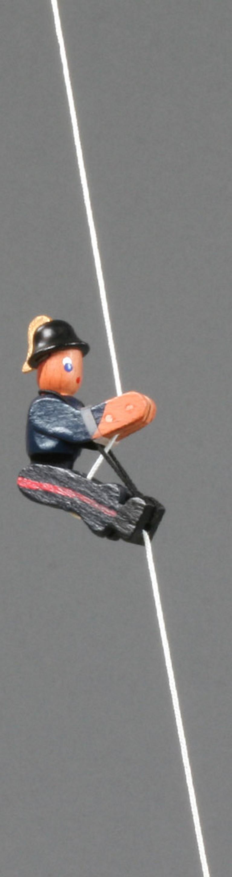 Kletterfigur Feuerwehrmann in traditioneller Uniform Kletterfigur Feuerwehrmann in traditioneller Uniform