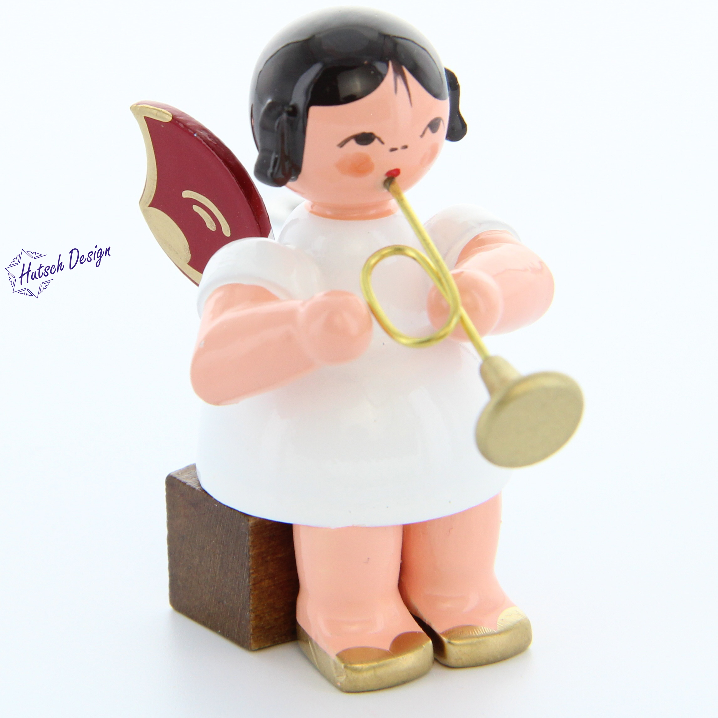 Engel sitzend mit Trompete, rote Flügel