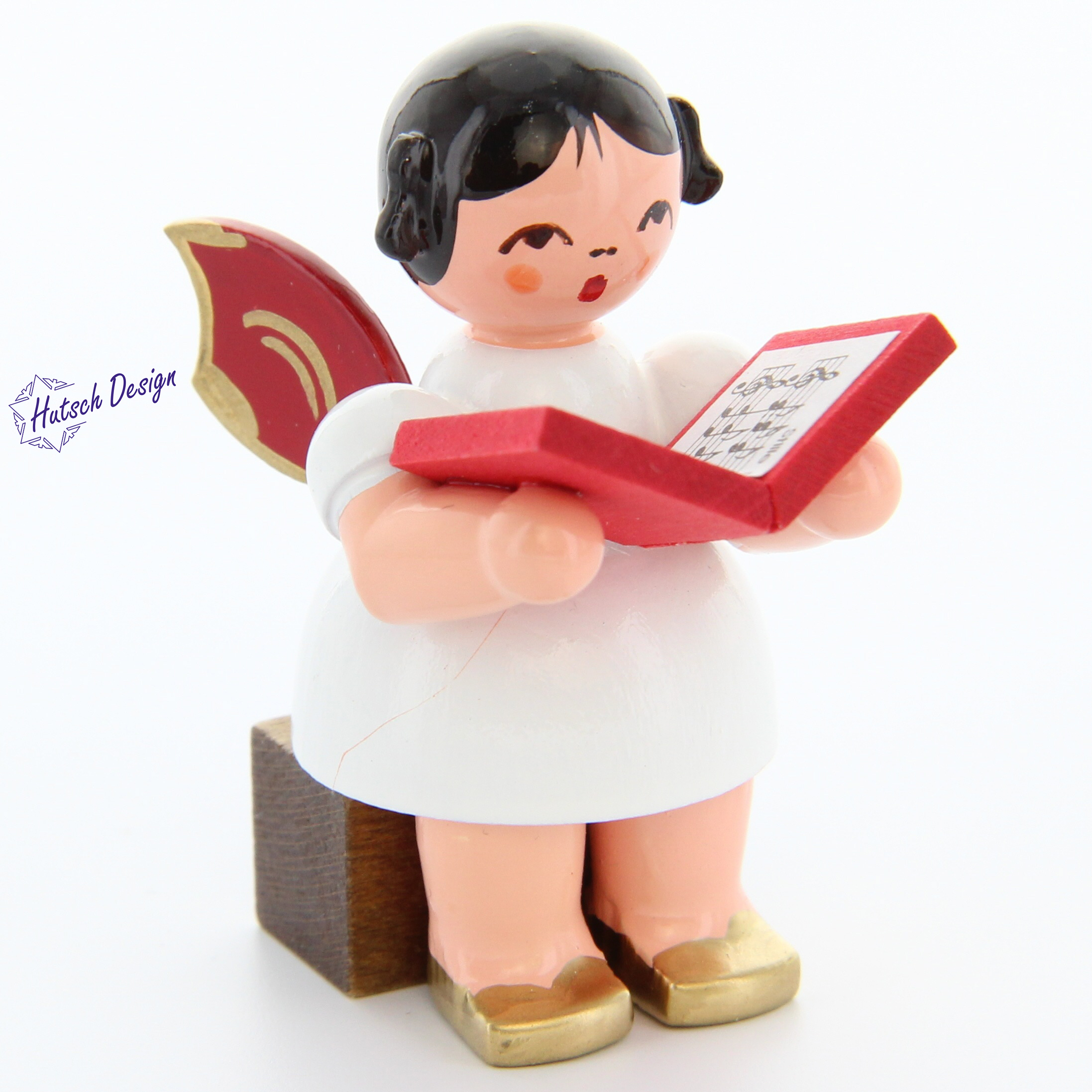 Engel sitzend mit Buch, rote Flügel